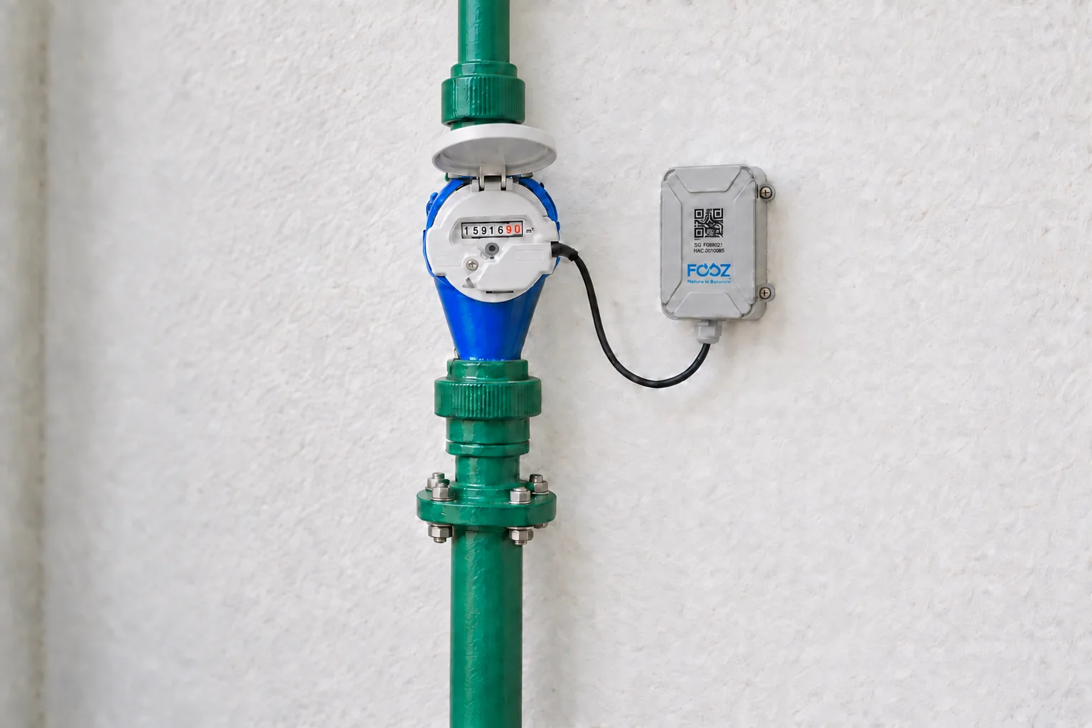 Ilustração de hidrômetro instalado em tubulação com módulo de telemetria FOOZ fixado na parede ao lado.